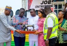 Mr Ignatius Baffour Awuah (second from left)trying his hands on a sewing machine