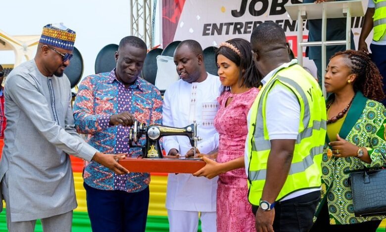 Mr Ignatius Baffour Awuah (second from left)trying his hands on a sewing machine