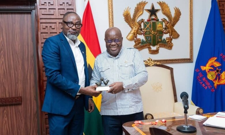 Mr Osei Asibey presents an armwrestling souvenir to the President (right)
