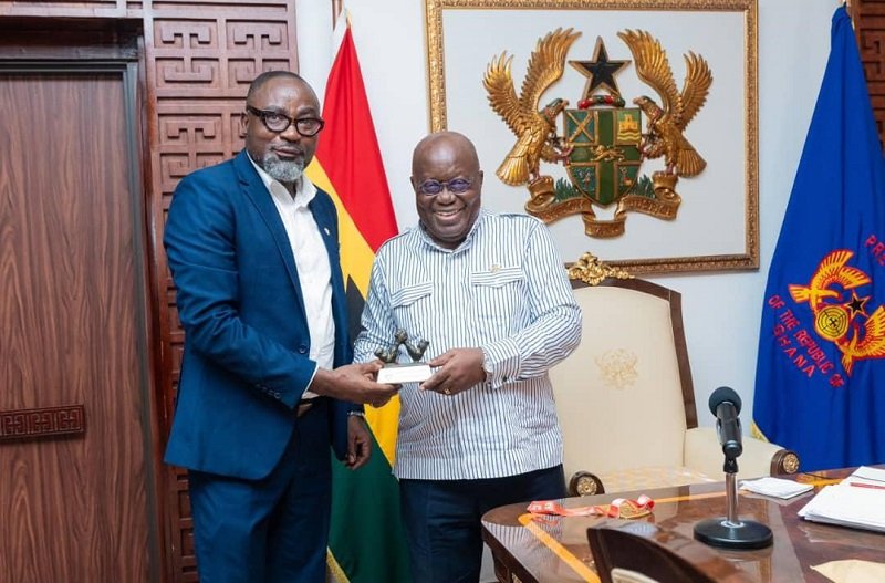 Mr Osei Asibey presents an armwrestling souvenir to the President (right)