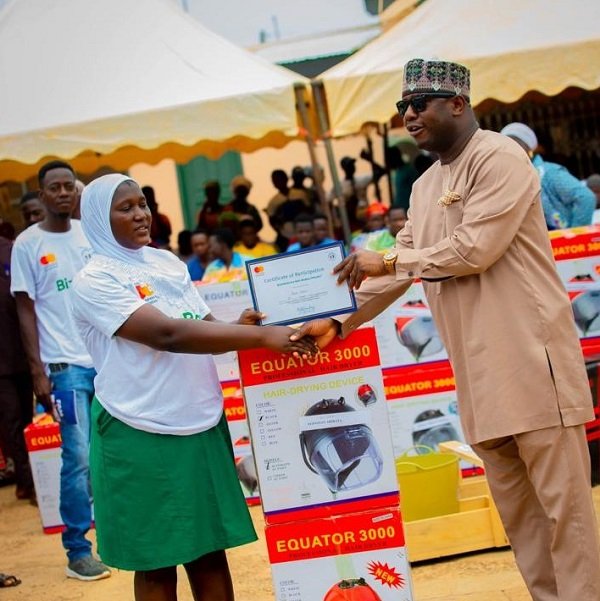 Alhaji Farouk Aliu Mahama presenting an item and certificate to one of the beneficiaries