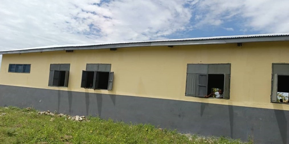 Mr Isaac Adongo (second from right) handing over the rehabilitated classroom block to a representative of the Bolgatanga Municipal Assembly