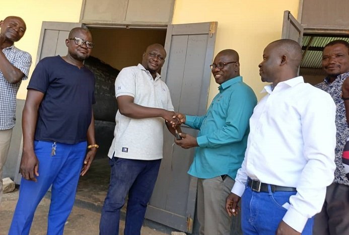 Mr Isaac Adongo (second from right) handing over the rehabilitated classroom block to a representative of the Bolgatanga Municipal Assembly