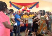 • Mr Afetor (left ) presenting the books to Mr Henry Nomoo, Headteacher of Manhean TMA 2 JHS