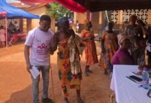 • A health worker assisting an aged woman to visit the consulting room, while others wait for their turn at the Subri programme