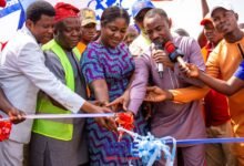 • Ms Manu (middle) being assisted by other dignitaries to cut the tape to open the road