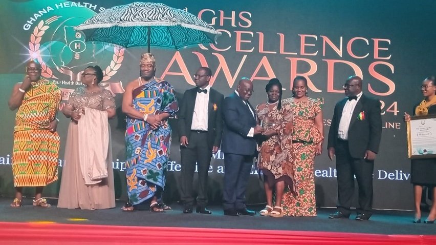 • President Akufo-Addo (fifth from right) presenting a plaque to Mrs Opoku-Kyeremeh, the Most Outstanding Worker-National Level