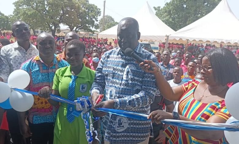 Dr Hafiz Bin Salih (middle) being assisted by Ms Mercy Babachuweh, Headmistress, NAVASCO, to cut the tape to open dormitory facility