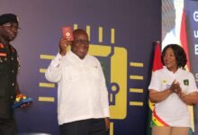 President Akufo-Addo showing the Chip Embedded Passport after the launch. Applauding is Ms Shirley Ayorkor Botchhwey. Photo. Ebo Gorman