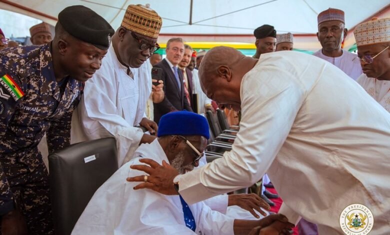 President Mahama, bowing, in a handshake with the National Chief Imam seated