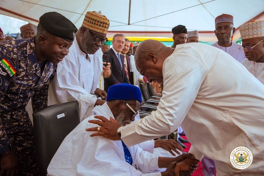 President Mahama, bowing, in a handshake with the National Chief Imam seated