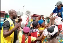 Lion Seyram Ahiabor (left) with the team sharing bags of food to some of the kayayes