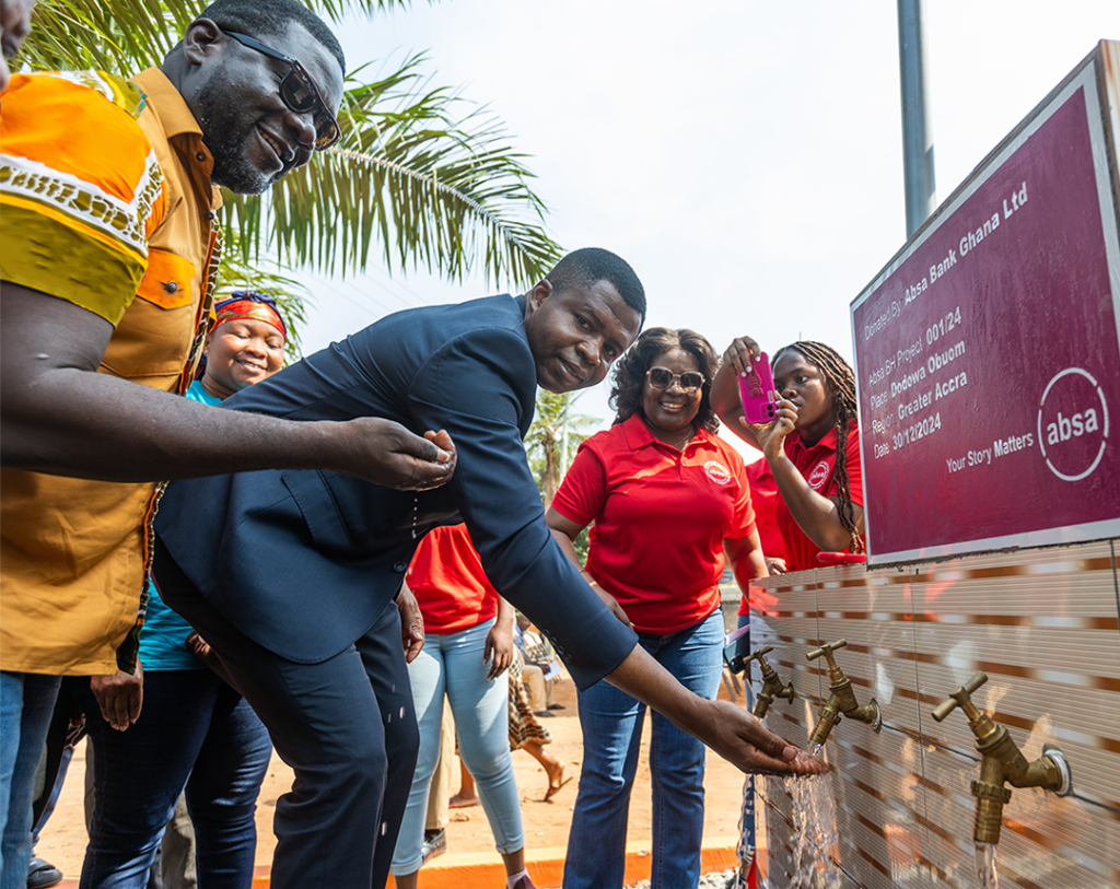 • Mr Edward Nartey Botchway, MD, Absa Bank expereincing the flow of water from one of the boreholes
