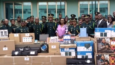 • Comptroller General Kwame Asuah Takyi (middle) and officials from IOM and GIS senior officers standing by the items after the presentation