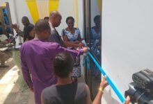 Prof. Azeko Tahiru Salifu (middle) being assisted to cut the tape to open the facility