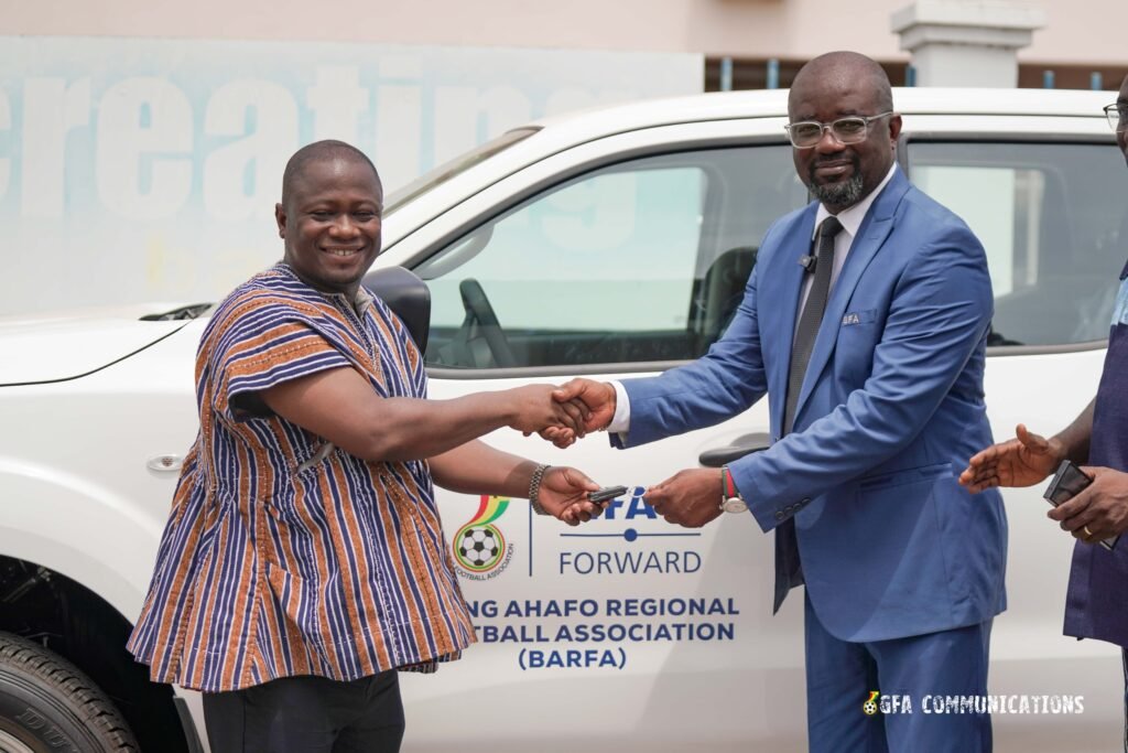 Brong Ahafo Regional Football Association chairman Dr Charles Osei Antoh receiving the keys to his vehicle from Mr Okraku