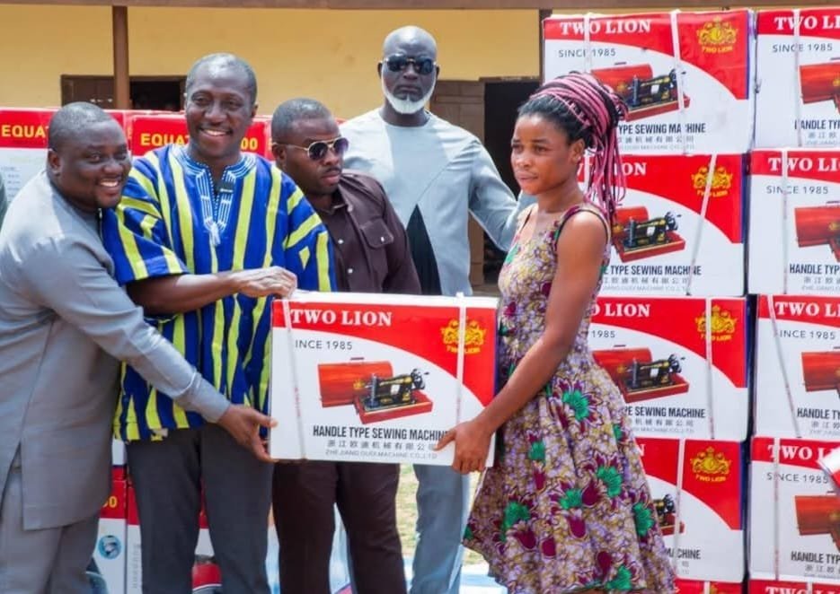 • Mr Alexander Afenyo-Markin (second from left) handing over a sewing machine to one of the women