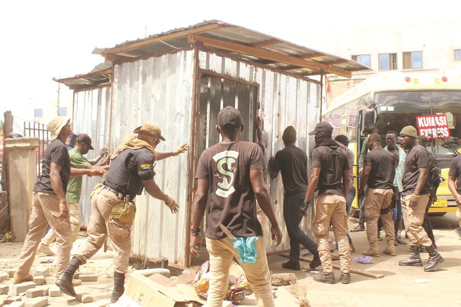 • Affected victims with their items (Inset): AMA taskforce pulling a container from unauthorised place at circle Photo: Ebo Gorman