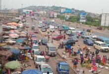 Traders busily selling on the pavement of the Mallam market road.