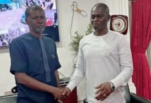 Mr Awal (left) in a handshake with Dr Kuyon at the meeting