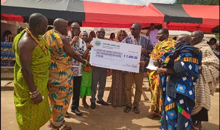 • Mr Samuel Aboni (third fromleft) presenting the dummy cheque to Mr Peter Bosrotsi (fourth from right). Looking on are Chiefs, elders and opinion leaders of Avatime Vane