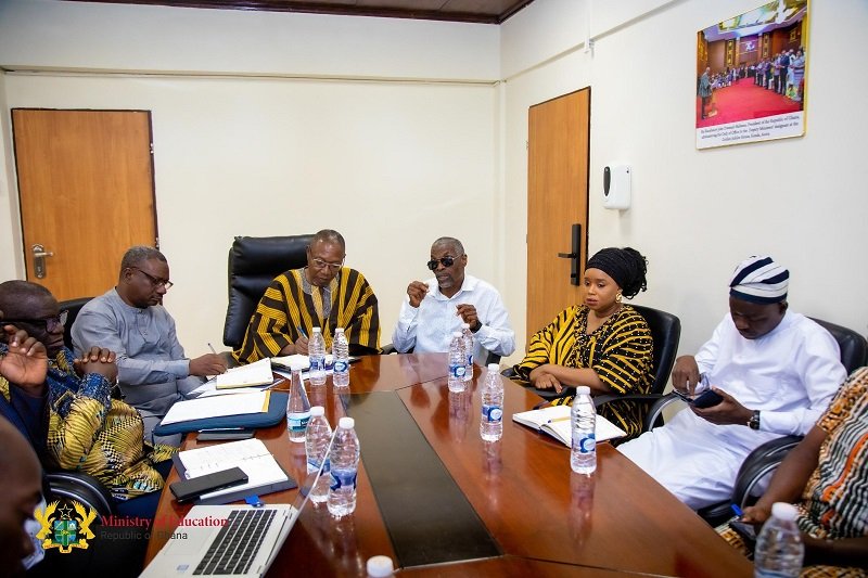 • Mr Apaak (head of table) in a meeting with the committee members