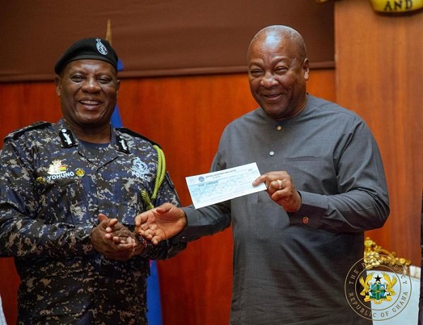 President Mahama (right) receiving the cheque from IGP Christian Tetteh Yohuno