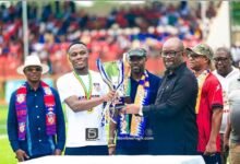 • Mr Kurt Okraku presenting the trophy to the skipper of Hohoe United while officials of the club watch on in adminiration