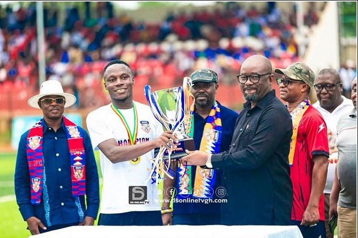 • Mr Kurt Okraku presenting the trophy to the skipper of Hohoe United while officials of the club watch on in adminiration