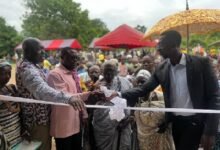 • Mr Park Davis Magyigbe (second from left) being assisted by other chiefs to cut the tape to open the facility