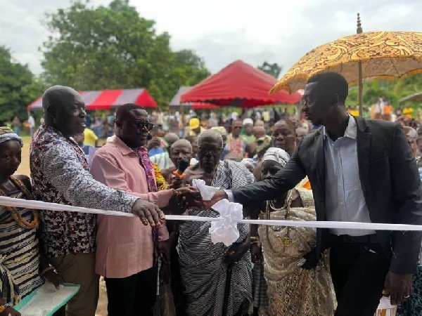 • Mr Park Davis Magyigbe (second from left) being assisted by other chiefs to cut the tape to open the facility