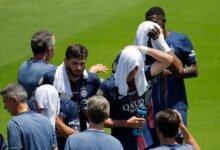 Paris St Germain players cooling down with wet towels over their heads during a break in play in their match with Atletico Madrid