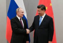 • Russian President Vladimir Putin shakes hands with Chinese President Xi Jinping