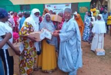 • Sheikh Ibrahim (right) presenting the packages to the beneficiaries