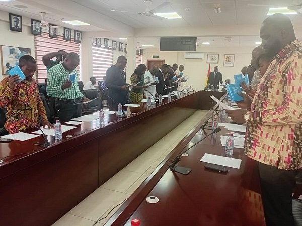 Mr Haruna Iddrisu (middle) swearing-in the govering board of STU