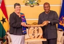 • Mrs Virginia Palmer receiving a gift from President John Mahama