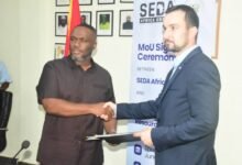 • Mr Kenneth Adjei (left) presenting the documents to Mr Habat Photo: Seth Osabukle