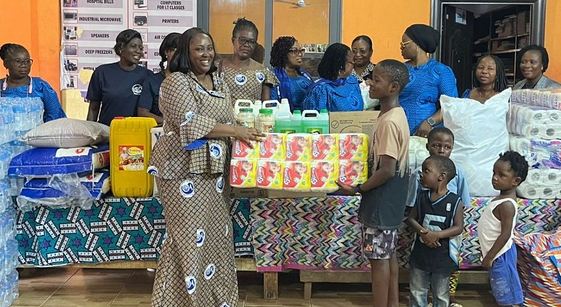 • Mrs Acquah presenting the items to one of the children at the orphanage