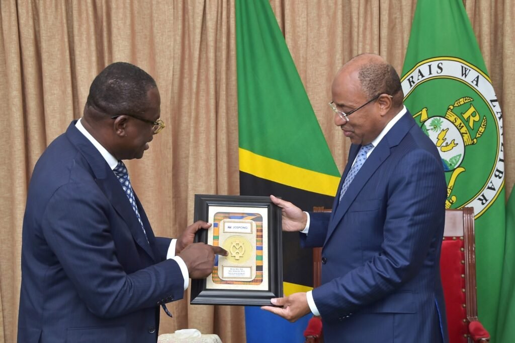 Dr. Joseph Siaw Agyepong (left) presents a flame symbol picture to President Mwinyi