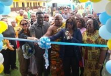 Dr Abena Asumani Antwi being assisted by Ms Beatrice Male and others cutting the tape to inaugurate the facility