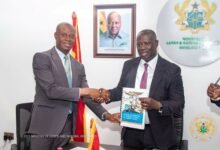 Emmanuel Armah-Kofi Buah (right) receiving the report