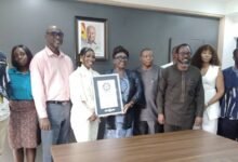 • Mrs Abla Dzifa Gomashie (middle) receiving the Record plaque from Ms Roselyn Akosua Mantey