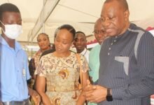 Dr Abdul-Rashid Pelpuo (right) and Ms Constance Swaniker (middle) inspecting locally manufuctured shoes displayed at the exhibition