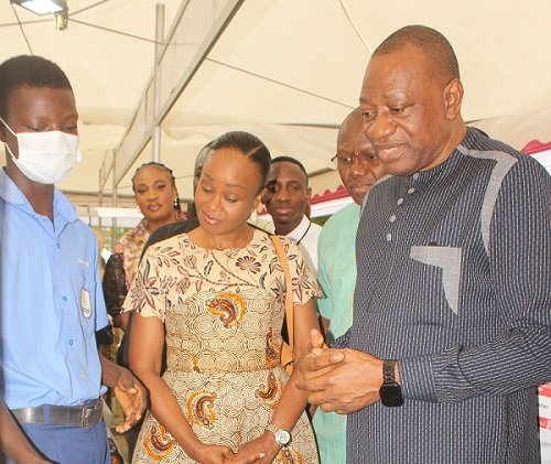 Dr Abdul-Rashid Pelpuo (right) and Ms Constance Swaniker (middle) inspecting locally manufuctured shoes displayed at the exhibition