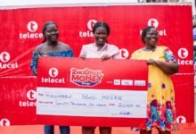 Maureen Bus-Moses (middle) displaying the cheque