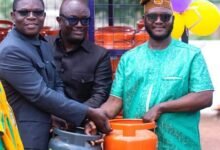 • Mr Gyan-Mensah (left) and Mr Zigah (second from left) replacing a customer empty cylinder with a new one