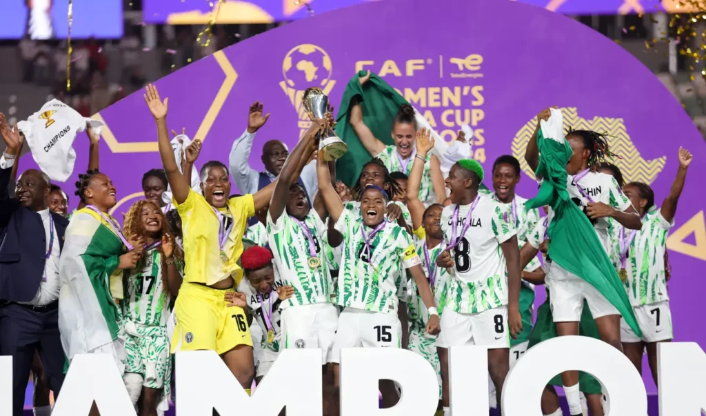 • Rasheedat Ajibade and Veronica Chinwendu joined by other teammates to lift the trophy