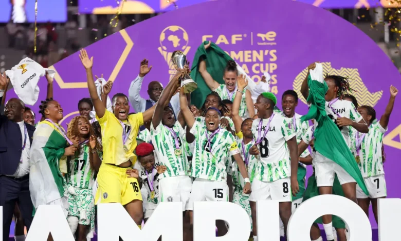 • Rasheedat Ajibade and Veronica Chinwendu joined by other teammates to lift the trophy