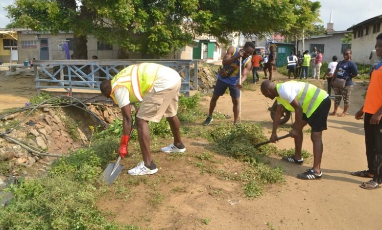 • Mr Anyetei (left) assisting in the clean-up exercise Photo: Victor A. Buxton