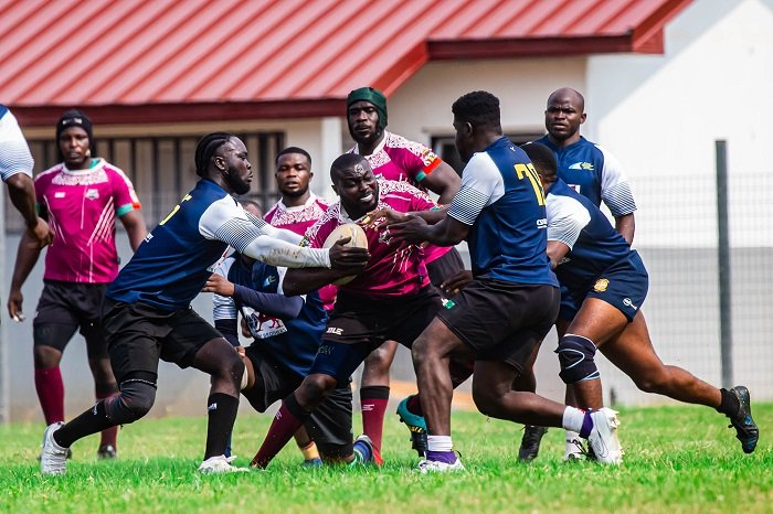 Captain of Skolars Riddick Alibah with the ball evading a tackle from players from Accra Panthers